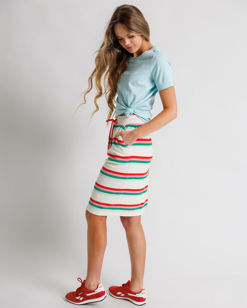 Model wearing a white, pink, green and blue striped short flutter sleeve terry knee length skirt.