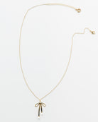 Gold necklace with a bow pendant on a white background