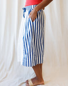 Person wearing blue and white striped pants against a white background