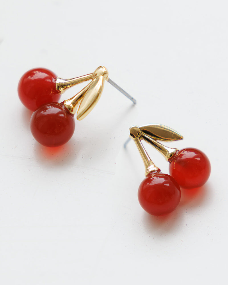 Cherry-themed earrings with red stones and gold branches on a white background