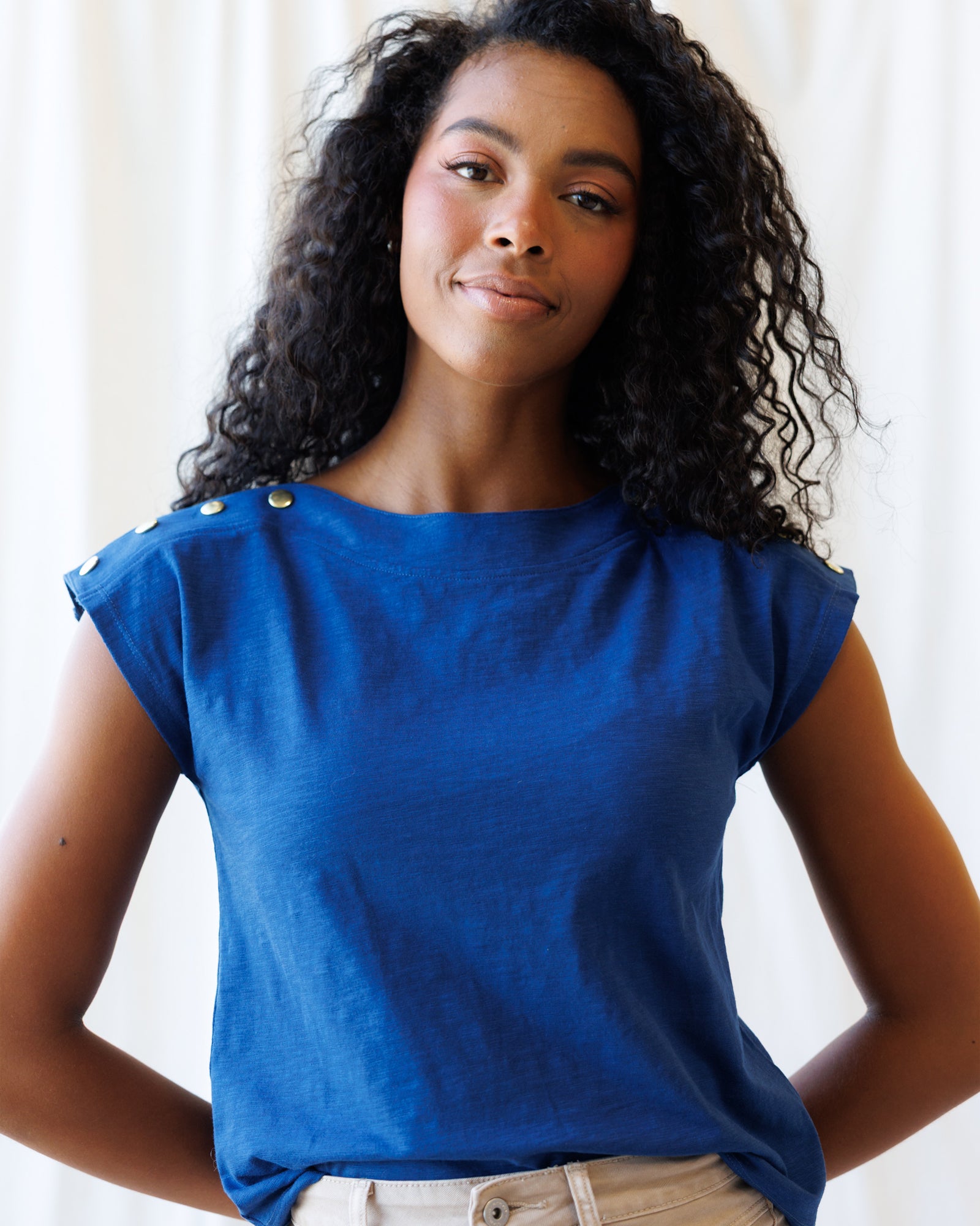 Woman wearing a blue top with a plain background