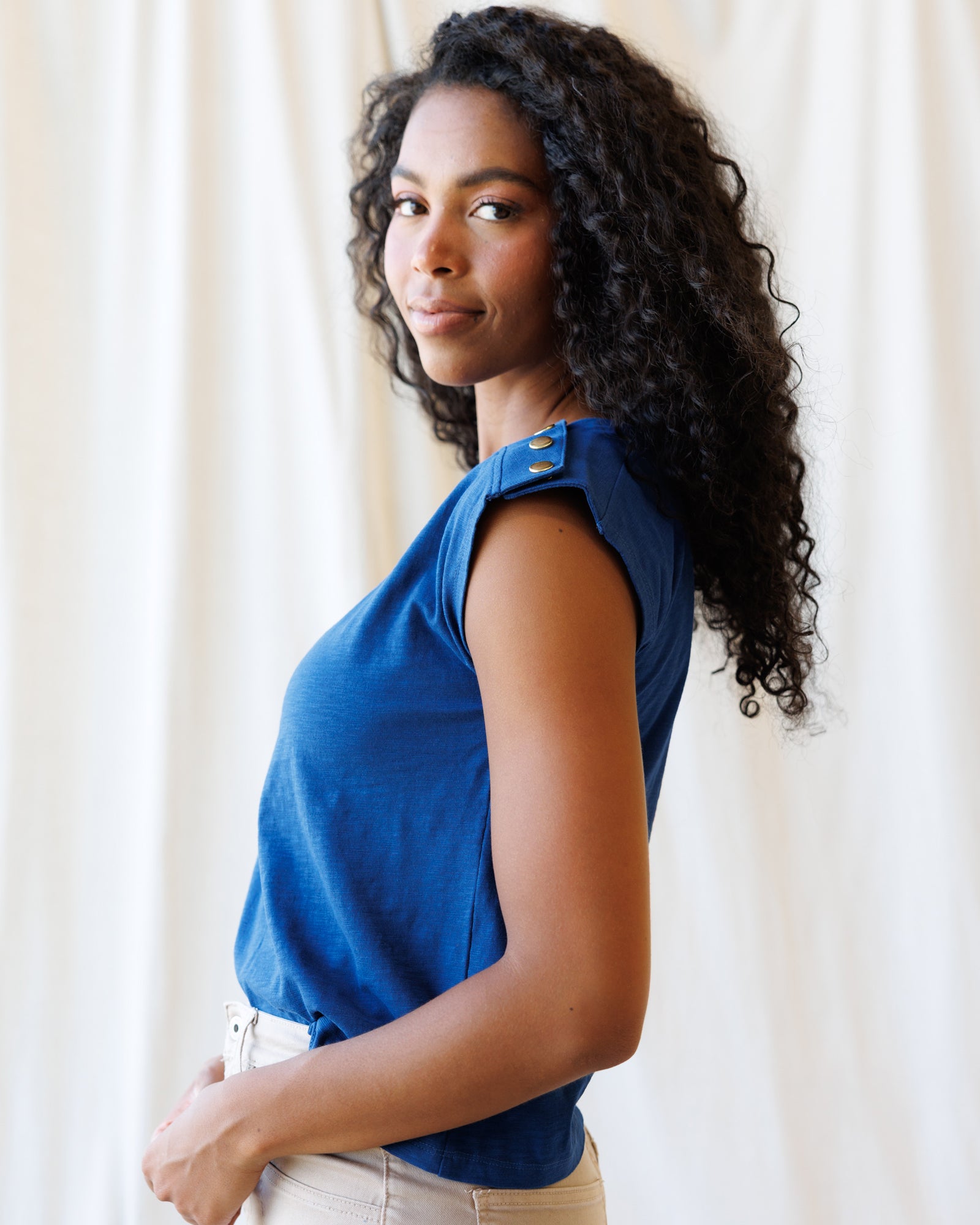 Woman wearing a blue top with a neutral background
