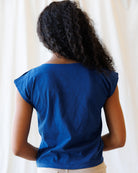Person wearing a blue shirt with a plain background