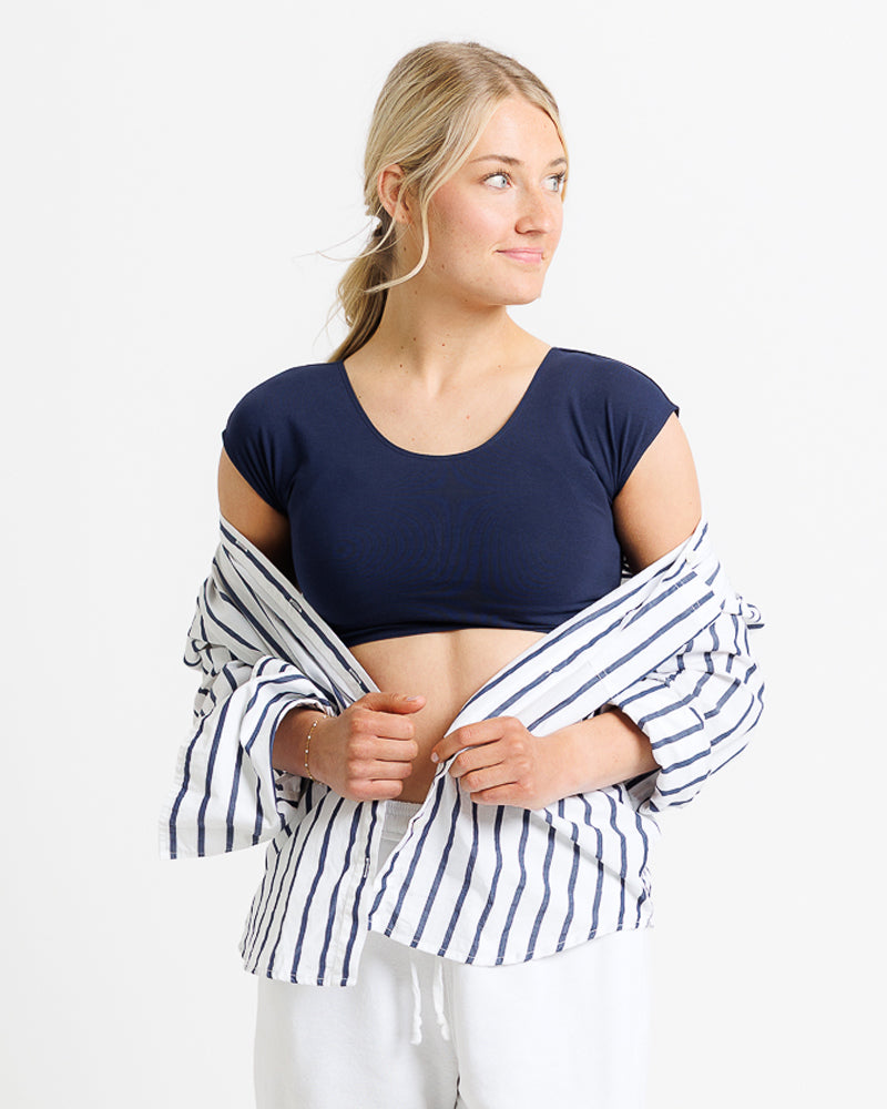 Model wearing a navy short sleeve scoop neck cropped tee.