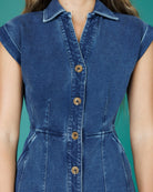Blue denim dress with button details on a teal background
