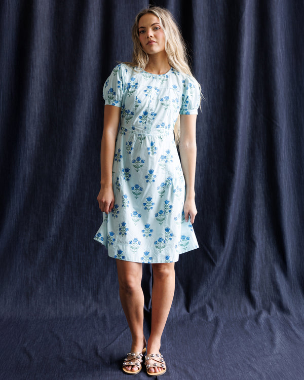 Woman wearing a floral dress against a dark blue background