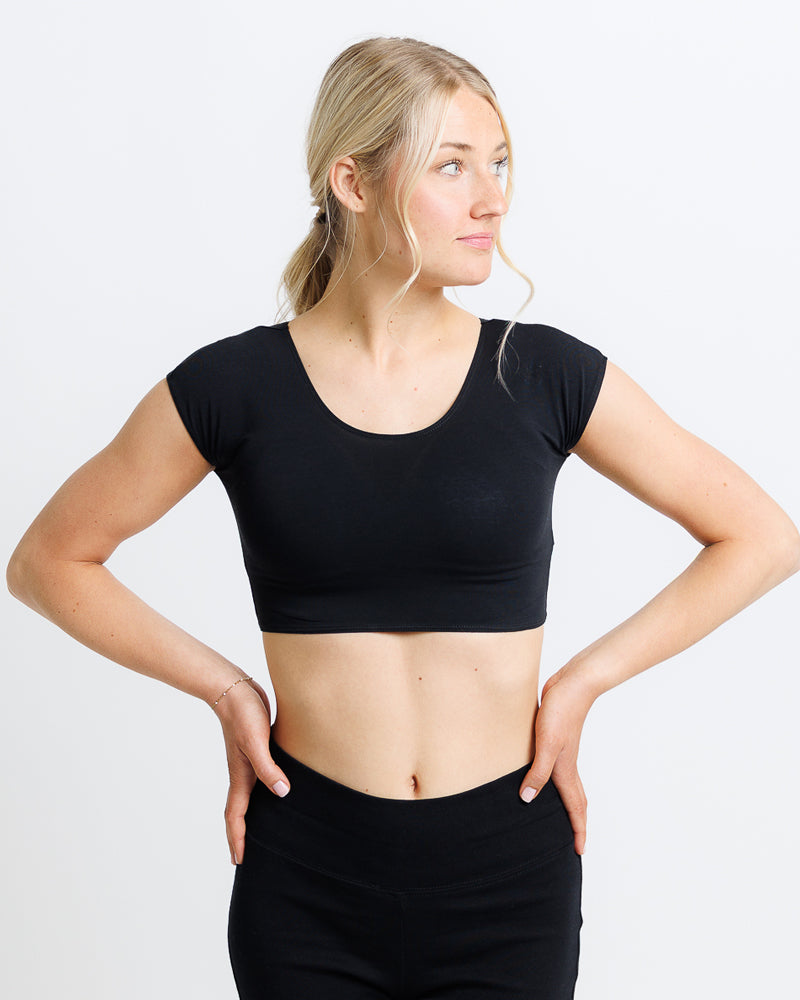 Model wearing a black short sleeve scoop neck cropped tee.