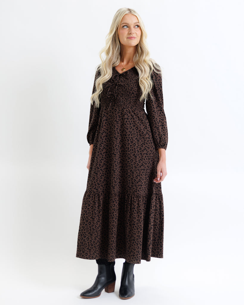 Woman wearing a brown animal print dress on a white background