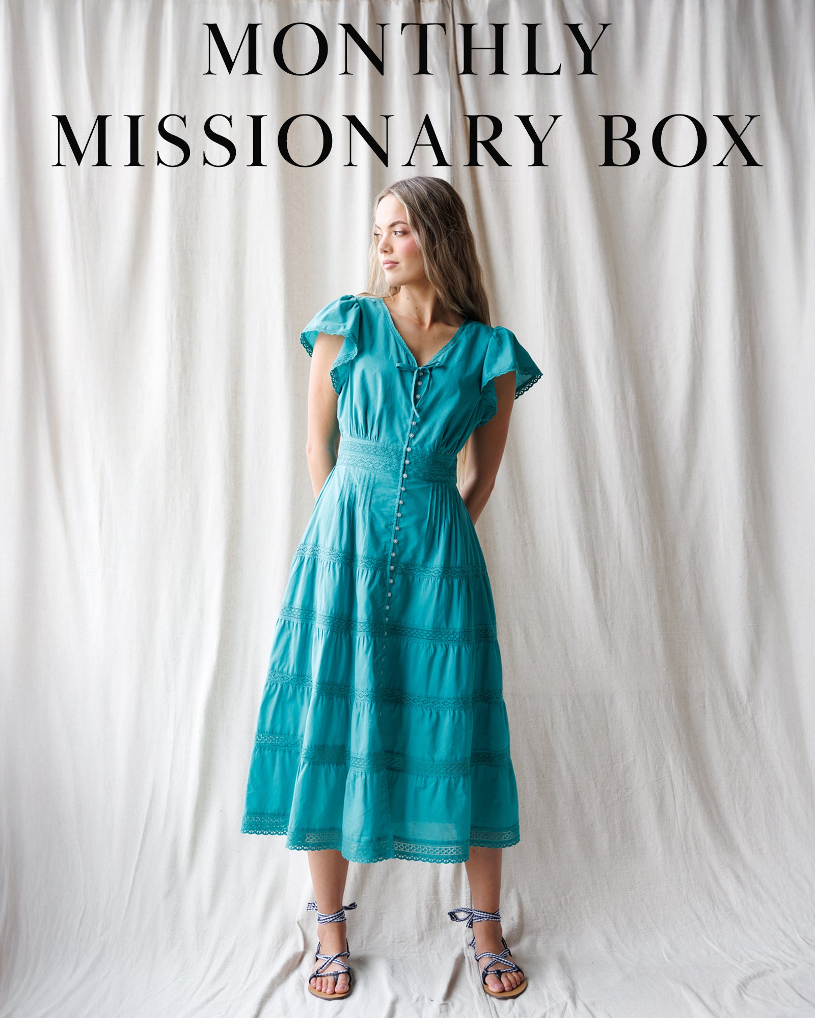 Woman wearing a teal midi dress with 'MONTHLY MISSIONARY BOX" in text