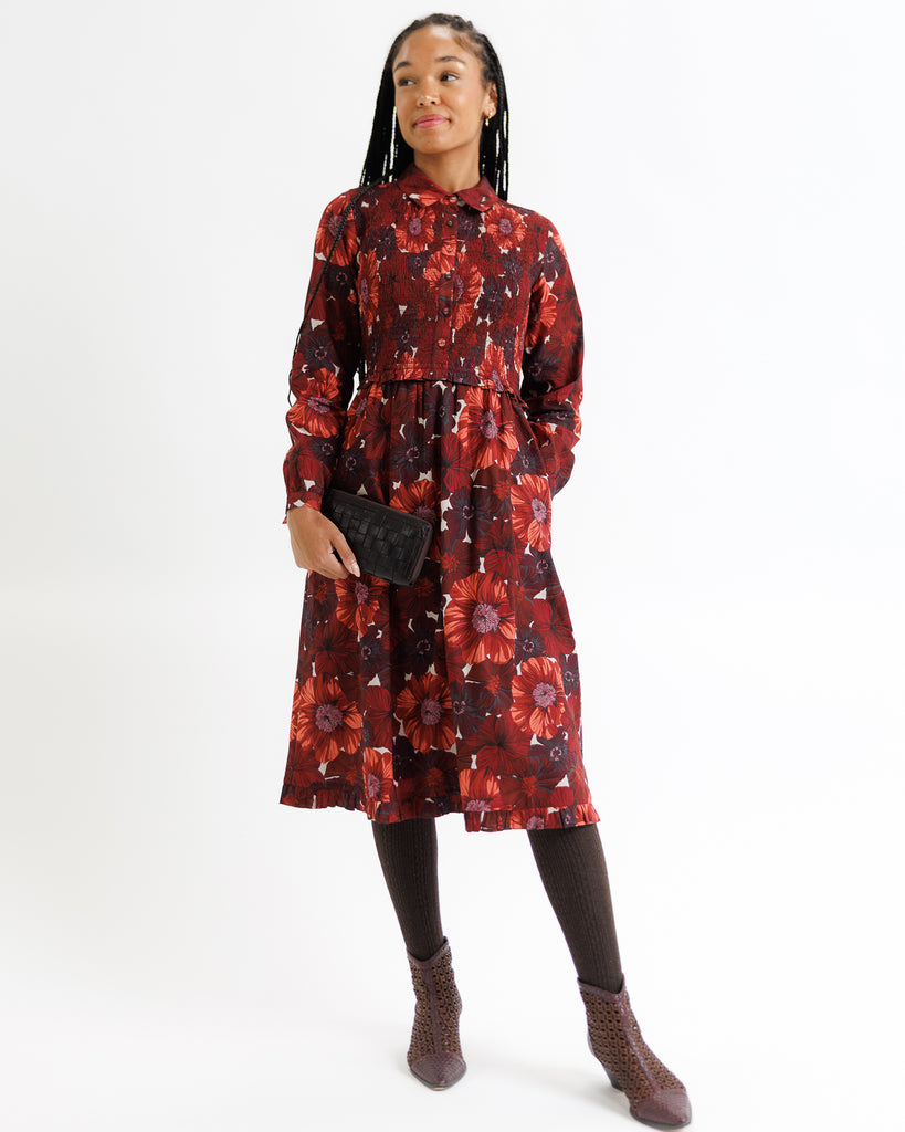 Girl wearing a red floral dress on a white background