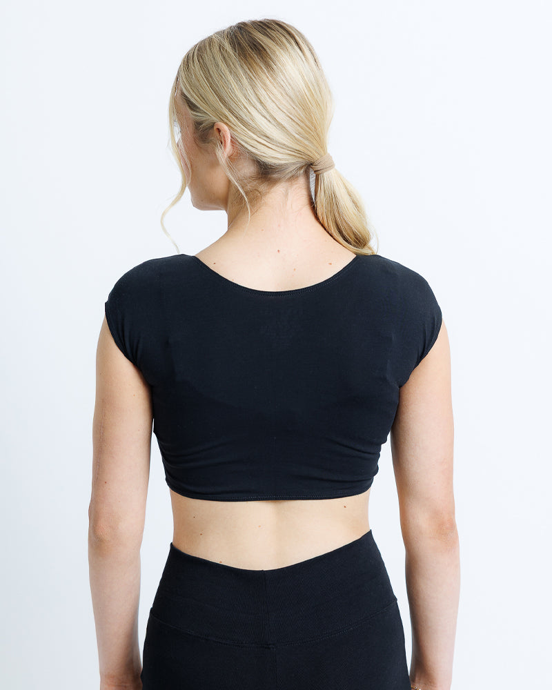Model wearing a black sleeve scoop neck cropped tee.