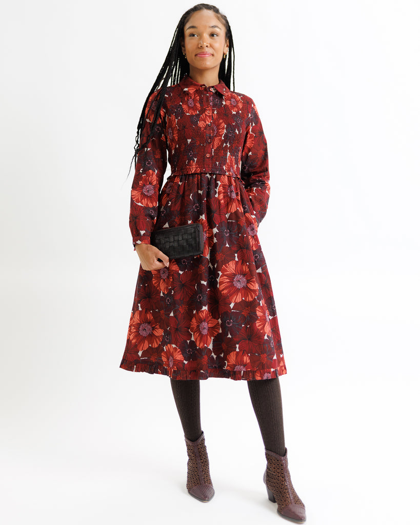 Woman wearing a red floral dress on a white background