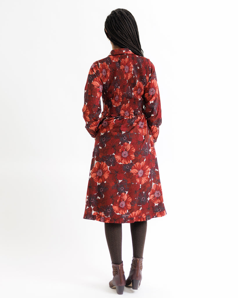 Person wearing a red floral dress on a white background