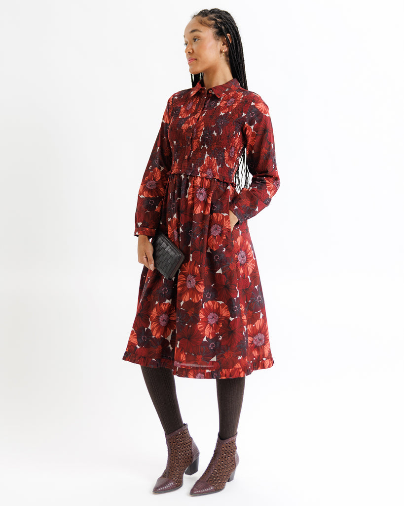 Woman wearing a red floral dress on a white background