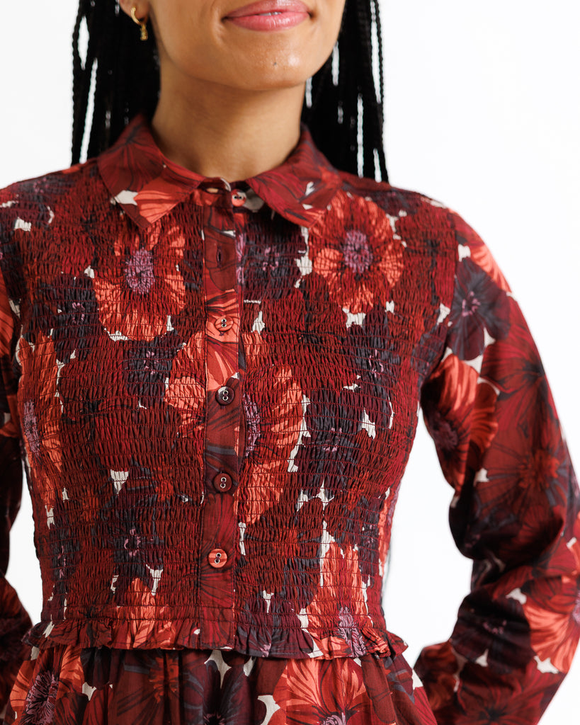 Red floral blouse worn by a model with a white background
