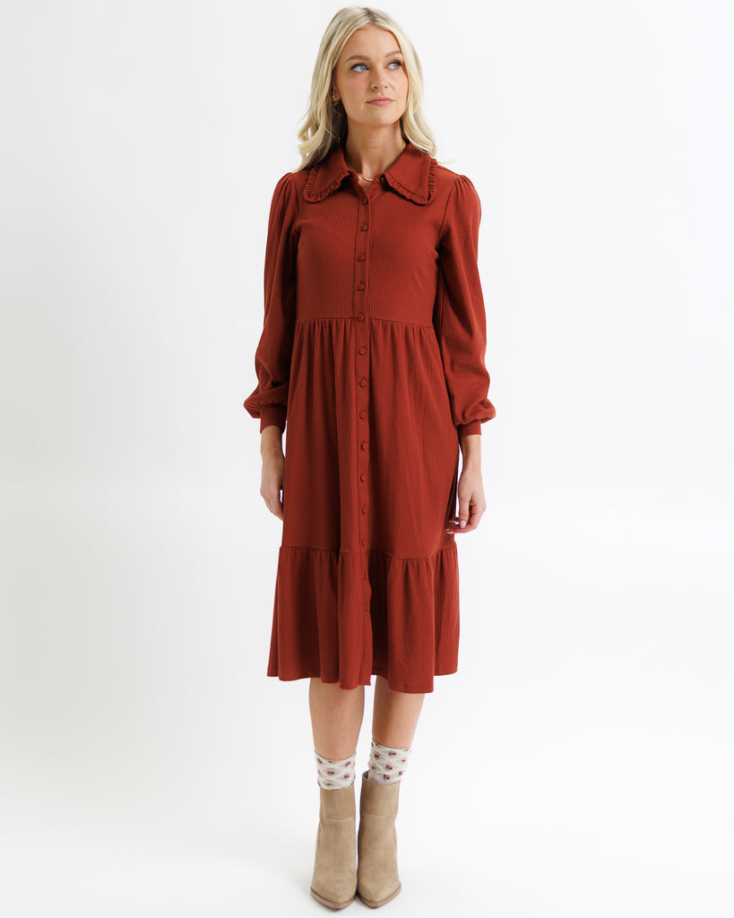 Woman wearing a rust-colored dress on a white background