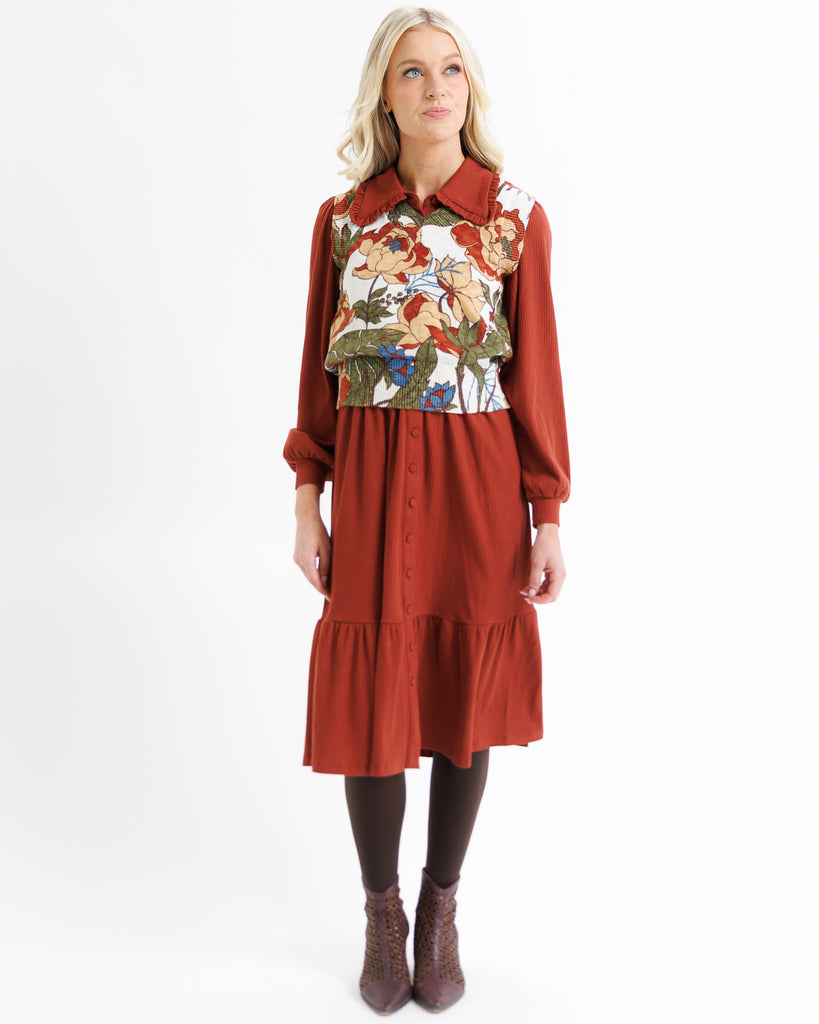 Woman wearing a red dress with floral pattern on a white background