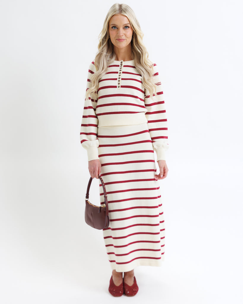 Woman wearing a red and white striped dress on a white background