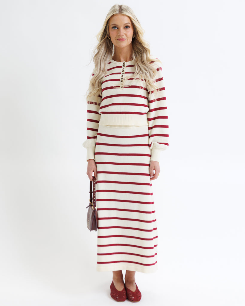 Woman wearing a red and white striped dress on a white background
