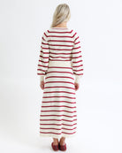 Woman wearing a red and white striped dress on a white background