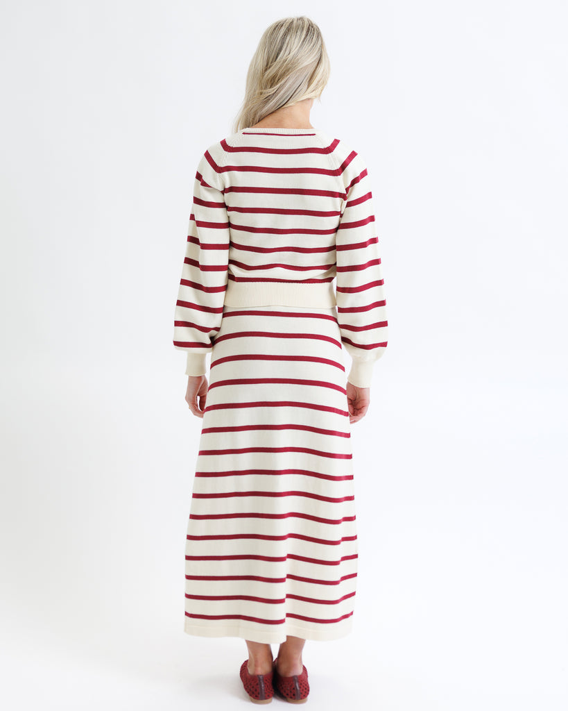 Woman wearing a red and white striped dress on a white background