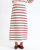 Woman wearing a red and white striped skirt on a white background
