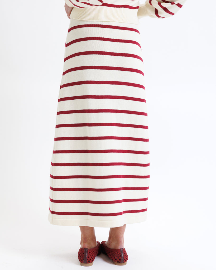 Woman wearing a red and white striped skirt on a white background