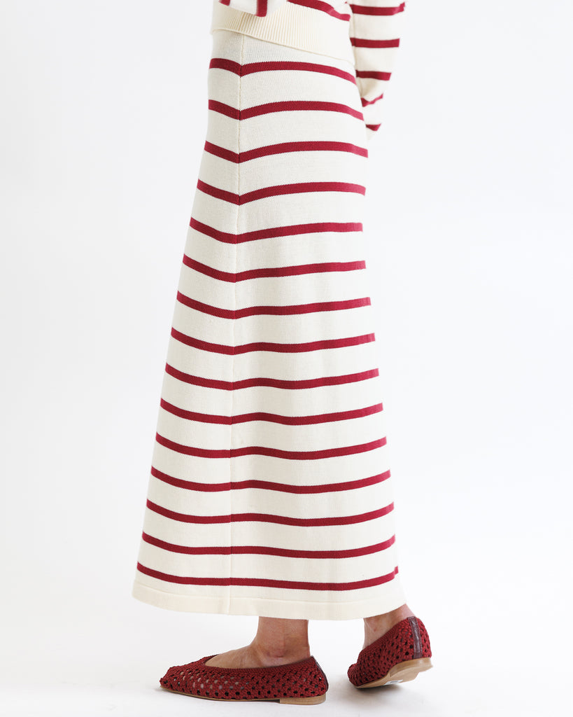 Red and white striped skirt worn by a woman on a white background