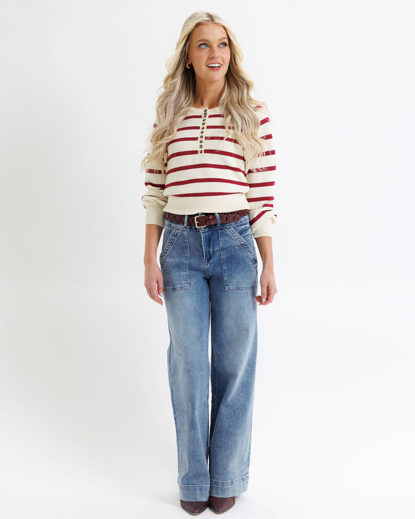Woman wearing a striped sweater and jeans on a white background