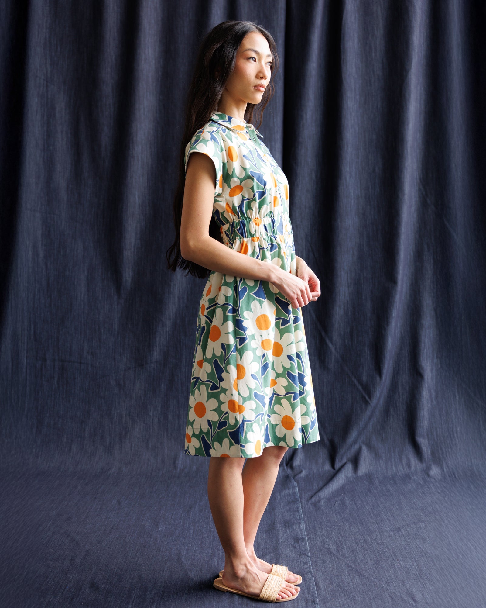 Woman wearing a floral dress against a dark blue backdrop