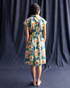 Woman wearing a floral dress against a dark background