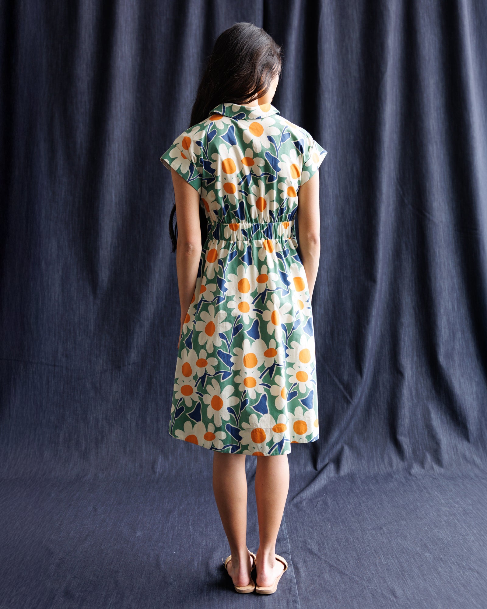 Woman wearing a floral dress against a dark background