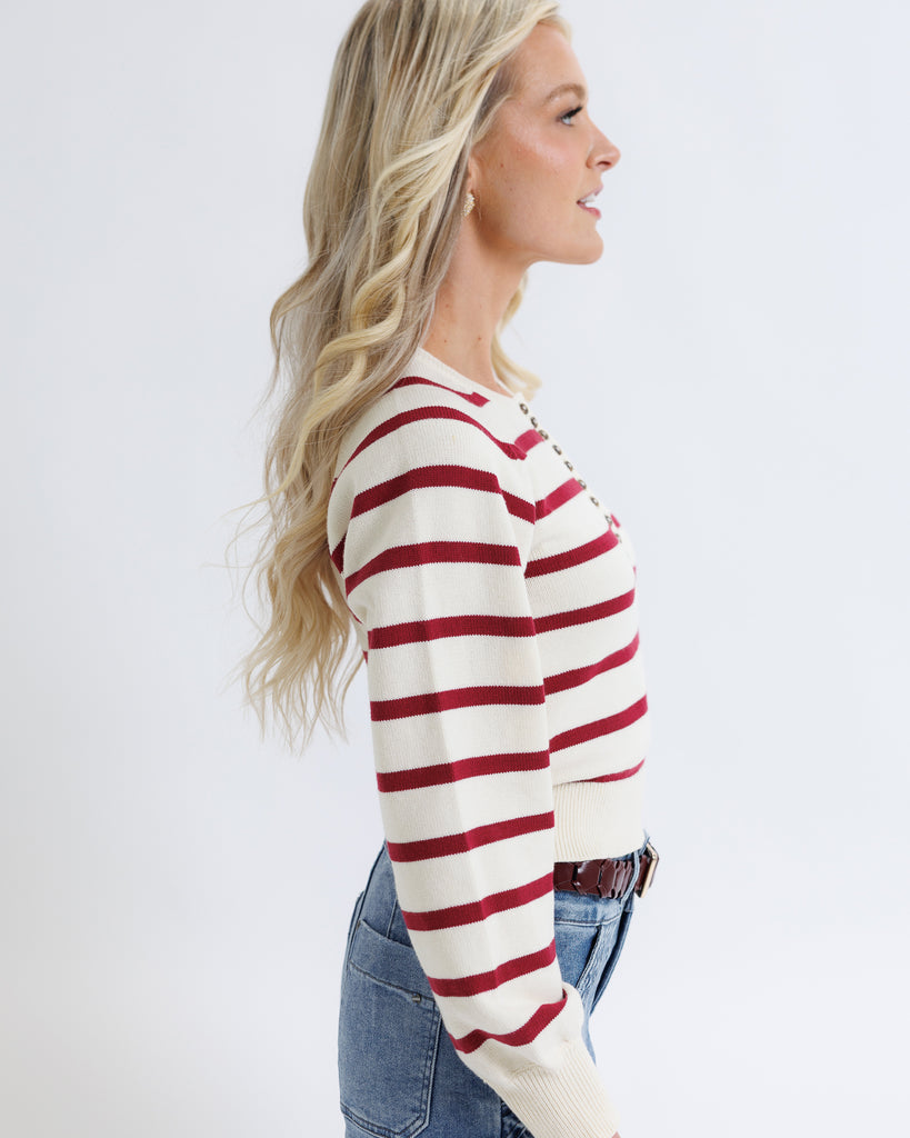 Woman wearing a red and white striped sweater on a white background