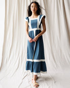 Woman wearing a blue and white dress against a plain background