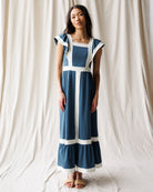 Woman wearing a blue and white dress against a plain background