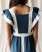 Woman wearing a blue and white dress with smocked back