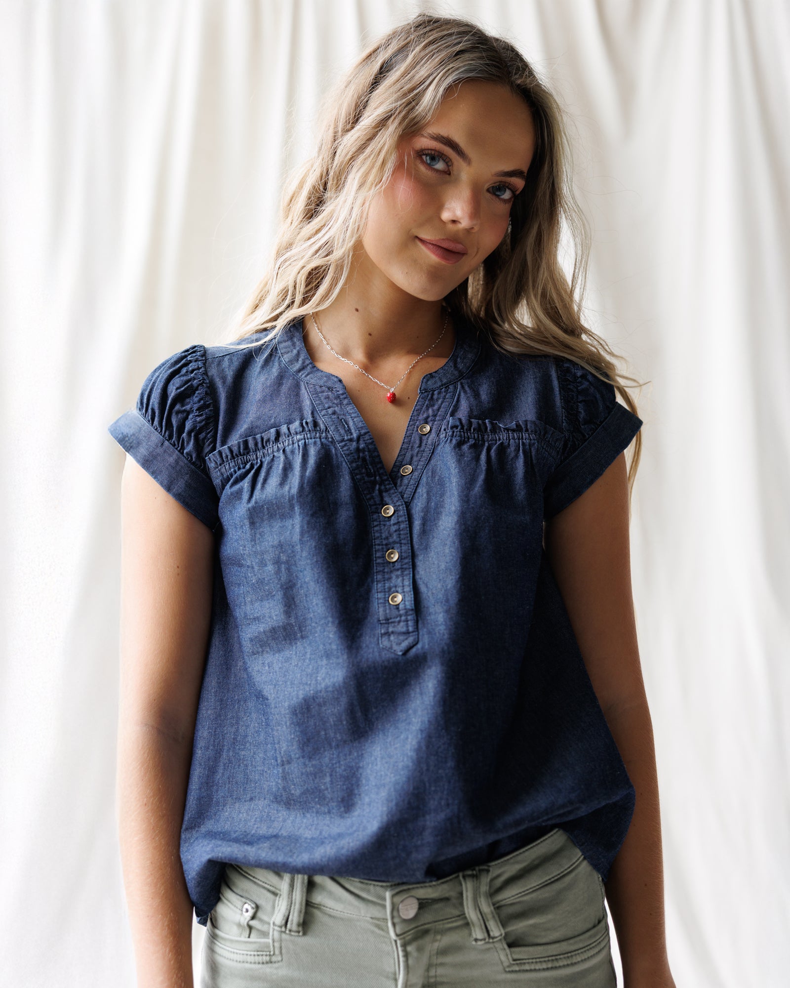 Woman wearing a blue denim top against a white background