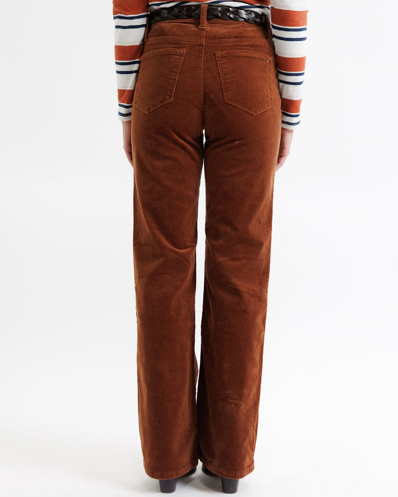Brown corduroy pants worn by a person on a white background