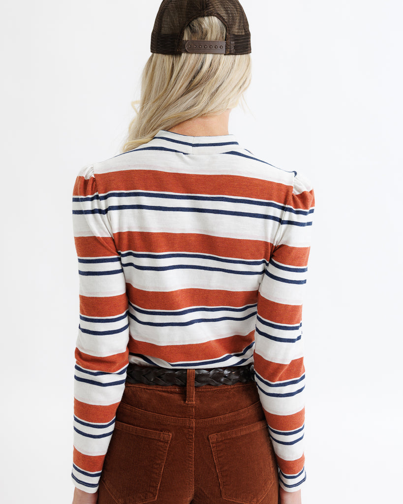 Person wearing a striped shirt with long sleeves on a plain background
