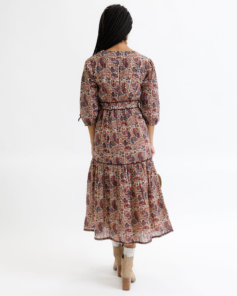 Woman wearing a patterned dress on a white background