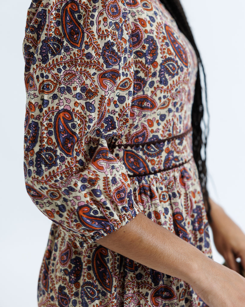 Close-up of a person wearing a patterned dress with a blurred background