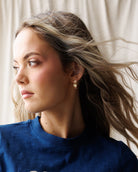 Woman wearing a blue t-shirt with 'Brooklyn New York' text against a white curtain background
