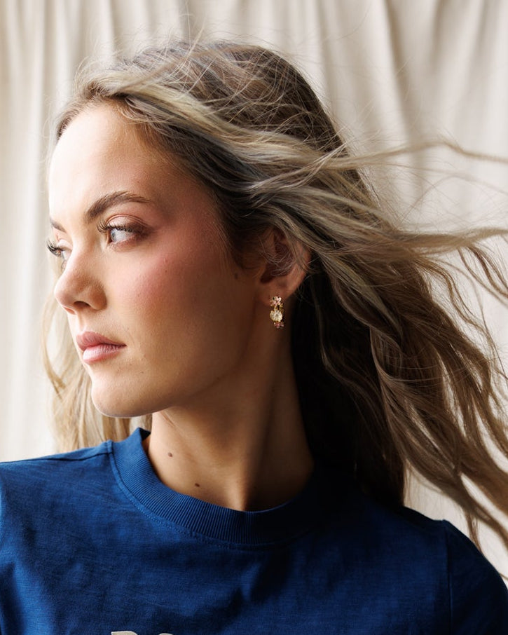 Woman wearing a blue t-shirt with 'Brooklyn New York' text against a white curtain background
