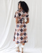 Back view of the floral patchwork midi dress highlighting the smocked elastic back waistband, hidden back zipper closure, and full coverage A-line skirt.