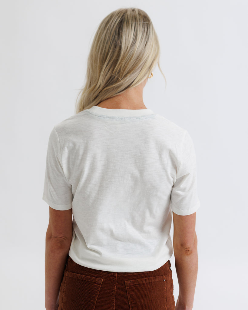 Person wearing a plain white t-shirt on a light gray background