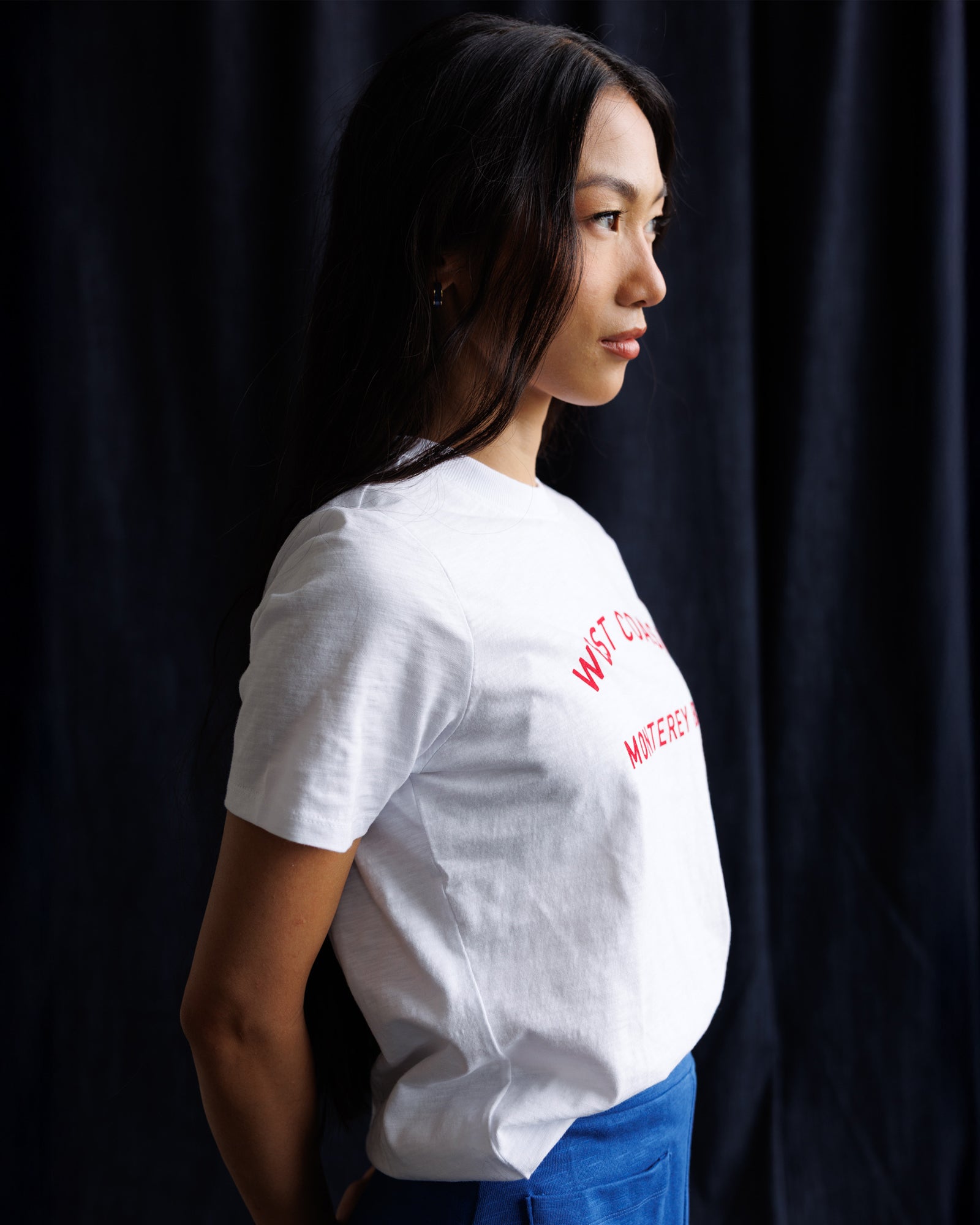 Person wearing a white t-shirt with red text against a dark background