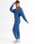 Woman wearing a blue outfit with a matching cap on a white background