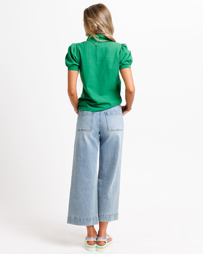 Model wearing blue wide leg, cropped, light blue denim jeans.