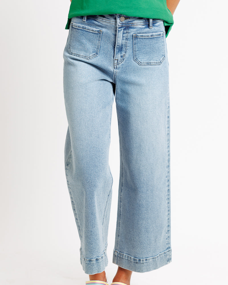 Model wearing blue wide leg, cropped, light blue denim jeans.