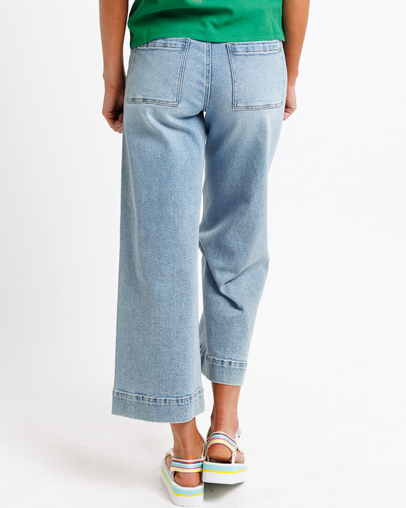 Model wearing blue wide leg, cropped, light blue denim jeans.